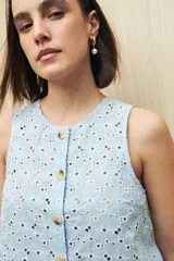 Musculosa negra con bordado calado y cierre frontal con botones.