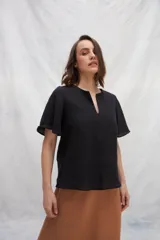 Blusa blanca de lino con escote en V y mangas cortas amplias.