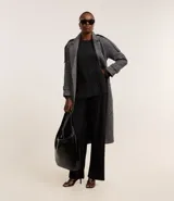 Suéter negro de poliéster con escote redondo y mangas largas. Presenta un diseño plisado en toda la prenda.