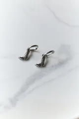 Aros dorados de acero quirúrgico hipoalergénico con dije colgante en forma de bota texana con detalles calados.