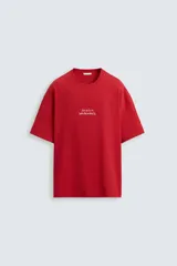 Camiseta roja de corte holgado, cuello redondo y manga corta. Estampado frontal con texto en color blanco.