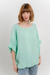 Blusa color beige confeccionada en lino, de corte holgado, mangas 3/4 y cuello redondo.