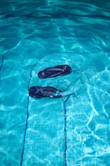 Ojotas de denim (mezclilla) color azul oscuro con tiras anchas acolchadas y un detalle bordado de la letra "N" en cuero en la tira.