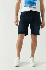 Bermuda de jean celeste con bolsillos delanteros y traseros, cierre con cremallera y presillas para cinturón.