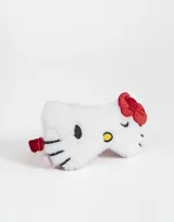 Antifaz de peluche blanco con la forma de la cara de Hello Kitty, con detalles bordados en negro y amarillo, moño rojo y elástico trasero.