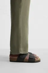 Sandalias negras con dos tiras anchas en el empeine con acabado engomado y ajustables mediante cierres adherentes. Plantilla con horma anatómica y suela de corcho.