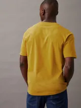 Remera amarilla de algodón con cuello redondo y logo de Calvin Klein estampado en el pecho.