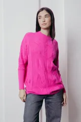 Sweater color crema de tejido de punto trenzado, con cuello redondo y corte holgado.