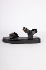 Sandalias negras de cuero sintético con agarre en tobillo y empeine, ambos con hebillas metálicas ajustables color dorado. Cuentan con una plataforma de 3cm.