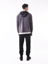 Campera deportiva azul con paneles negros en la parte superior y capucha. Cierre frontal con cremallera.