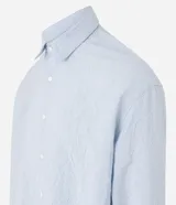 Camisa celeste de viscosa y poliéster con textura arrugada, cuello tradicional, manga larga y abotonadura frontal completa.