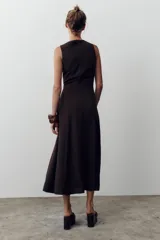 Vestido midi color marrón oscuro, sin mangas, con escote cuadrado, detalle de botones frontales y cinturón elástico con hebilla dorada.