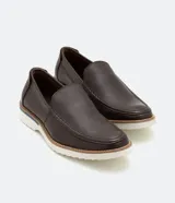 Zapato slip on marrón de cuero con suela blanca.