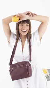 Bandolera color beige con correa extensible, cierre principal y bolsillos interiores, un bolsillo frontal, un bolsillo posterior y bolsillos laterales.