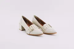 Zapato de cuero color crema con taco cuadrado y hebilla dorada.