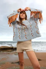 Sweater celeste de lana mohair con diseño de trenzas y apliques de cuero color suela.