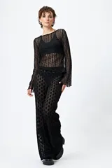 Pantalón de encaje negro con transparencias y cintura con elástico.