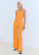 Top naranja con tirantes anchos y cuello cuadrado, con cierre frontal con botones.