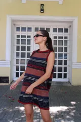 Vestido corto tejido a rayas horizontales en tonos beige, marrón, celeste y rojo. Diseño calado y corte holgado.