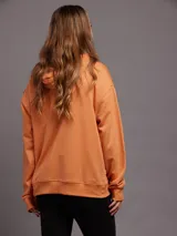Canguro color arena con cierre frontal, capucha con cordones y bolsillo tipo canguro.
