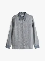Camisa celeste con estampado de lunares blancos, de corte regular, cuello francés, cartera oculta y puños con un botón.