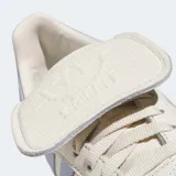Zapatillas Adidas Samba LT color crema con detalles en celeste y suela color caramelo.