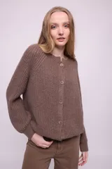 Cárdigan color ocre de tejido de punto con mohair, con cuello redondo, mangas largas y botones al tono. Silueta ligeramente oversize.