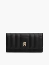 Billetera Tommy Hilfiger negra con diseño acolchado, cierre de solapa y logo metálico TH dorado al frente.