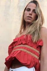 Top fruncido rojo con detalles de tirantes de cuero, ideal para combinar con prendas variadas.