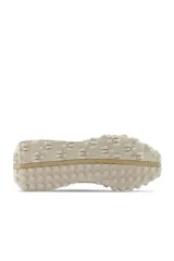 Championes New Balance color crema con detalles en beige y suela con diseño texturizado.