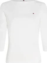 Remera blanca de algodón con cuello barco y mangas tres cuartos. Tiene el logo de Tommy Hilfiger bordado en el pecho.