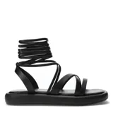 Sandalias negras con plataforma plana y tiras finas que se atan alrededor del tobillo.