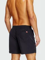Short de baño negro liso, con cordón ajustable en la cintura y detalle de franjas oscuras en el lateral derecho.