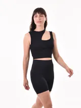 Musculosa corta de punto acanalado color negro, con breteles anchos y corte asimétrico con abertura en el hombro.