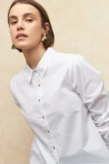 Camisa de manga larga de algodón color blanco, con botones de nácar y diseño clásico.
