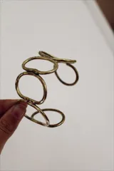 Pulsera rígida dorada con diseño de eslabones ovalados.