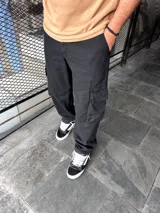 Pantalón cargo negro de corte amplio con bolsillos laterales y traseros con solapa.