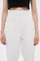 Pantalón babucha blanco con cintura elastizada y cordón ajustable.