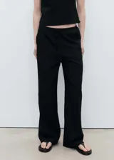 Pantalón largo negro de viscosa, poliamida, poliéster y elastano, con cintura elástica ajustable con lazo, tiro medio y diseño recto.
