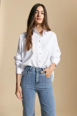 Jean de corte recto y tiro medio, color gris oscuro con efecto lavado. Presenta apliques de tachas metálicas pequeñas en la zona de los bolsillos delanteros.