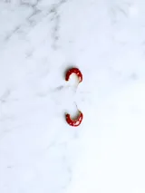 Aros tipo argolla pequeños, color rojo con apliques dorados.