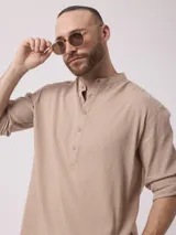 Camisa de manga larga color blanco, con cuello mao y cierre frontal con botones.