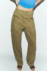 Jeans cargo de tiro medio color verde militar, con pernera recta. Presenta bolsillos laterales de plastrón con cierre de cremallera y cierre frontal con cremallera y botón.