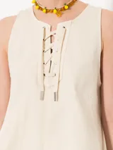 Musculosa color crema con escote con cordones cruzados.