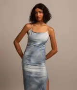 Vestido midi de tul con forro, estampado abstracto en tonos celeste y blanco, breteles finos cruzados en la espalda y corte al bies.