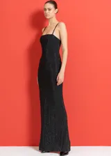 Vestido largo de fiesta negro con breteles finos y escote recto. Decorado con pedrería delicada y tejido elastizado.