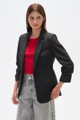 Blazer color crema de poliéster, de corte entallado, con cuello solapa y mangas largas.