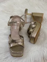 Sandalias de fiesta color champagne con plataforma y taco cuadrado, tiras cruzadas en el empeine y pulsera al tobillo con hebilla.