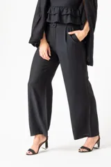 Pantalón negro de corte amplio, con diseño elegante y textura suave, ideal para completar un outfit.