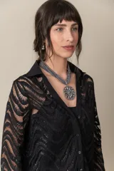 Blusa de encaje negro con hilos de plata y diseño de mangas largas, incluye musculosa en gasa.